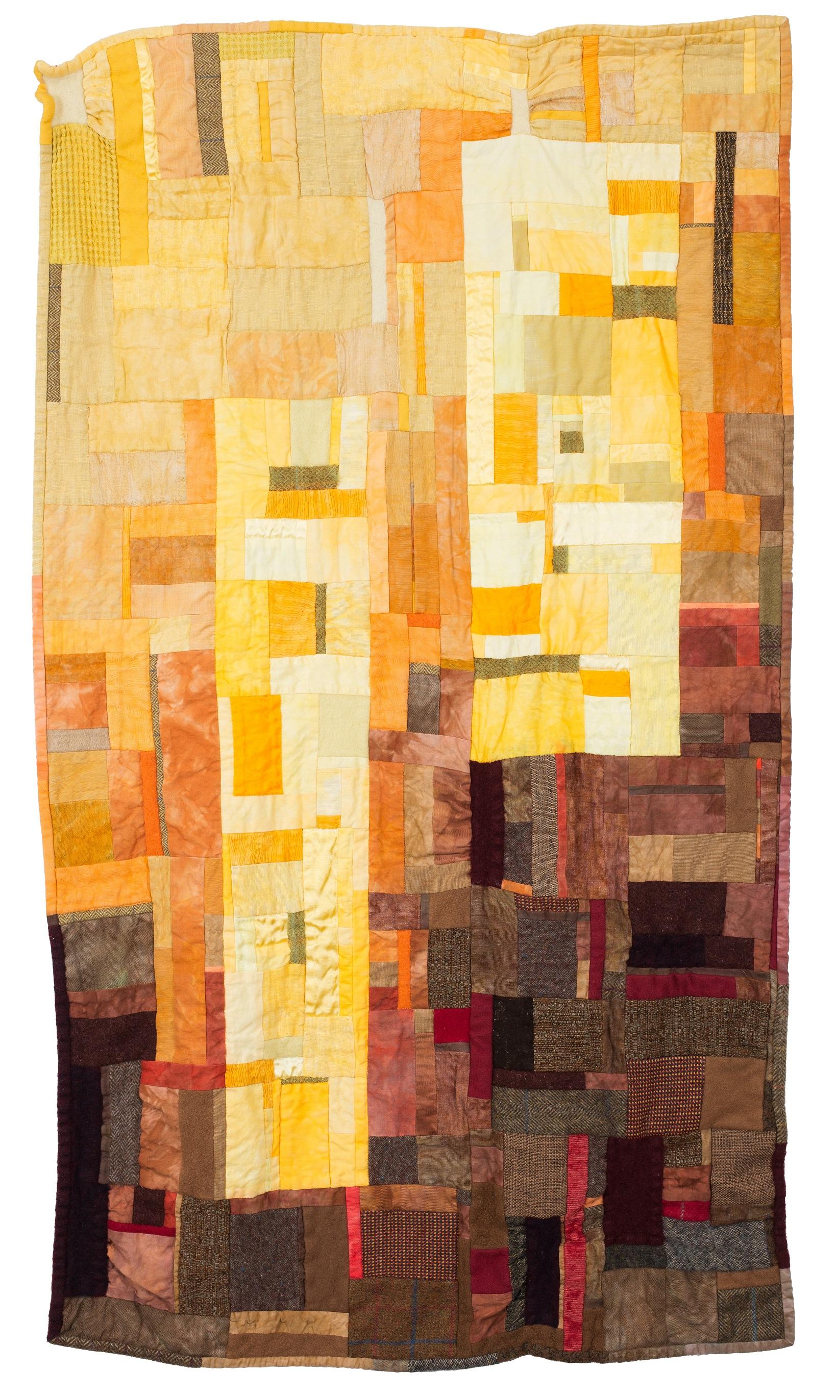 Image shows a modern improv patchwork of graded yellows and oranges, through to browns and maroons.