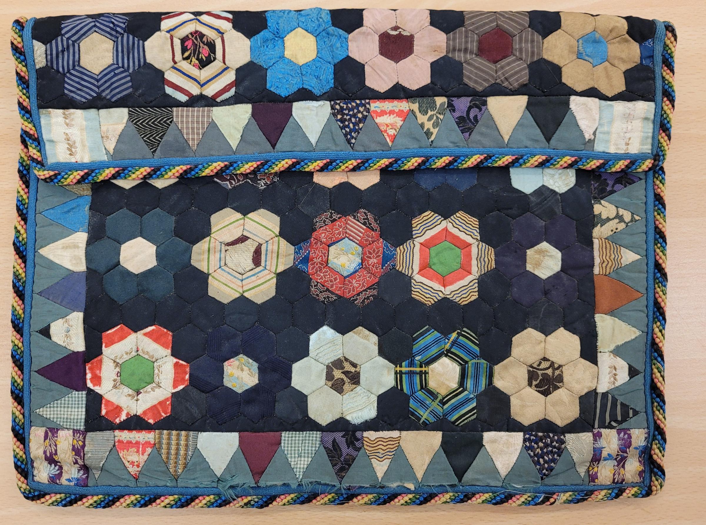 Image shows a fussy cut, hexagon patchwork case predominantly in shades of blue and neutrals.