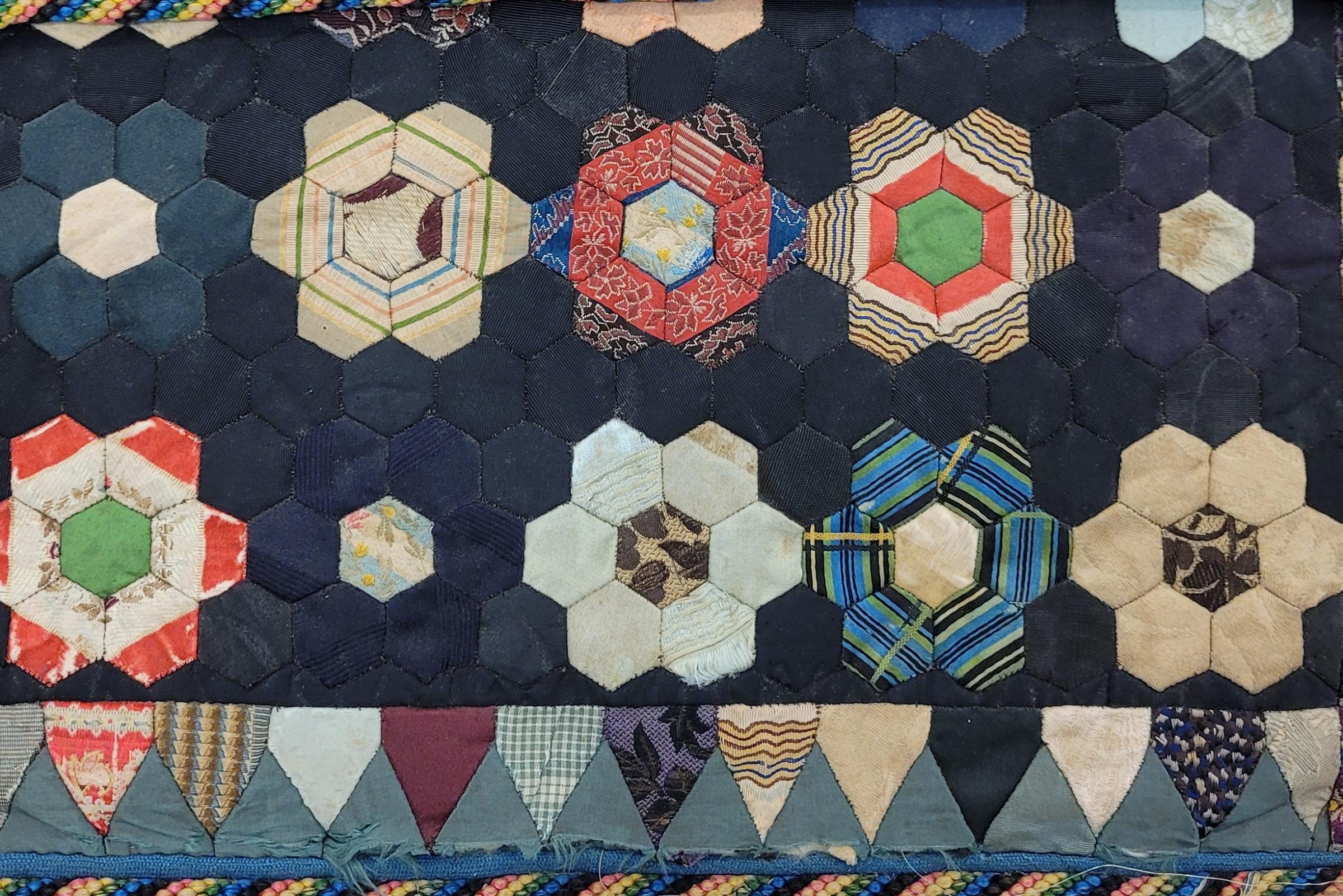 Image shows a fussy cut, hexagon patchwork case predominantly in shades of blue and neutrals.