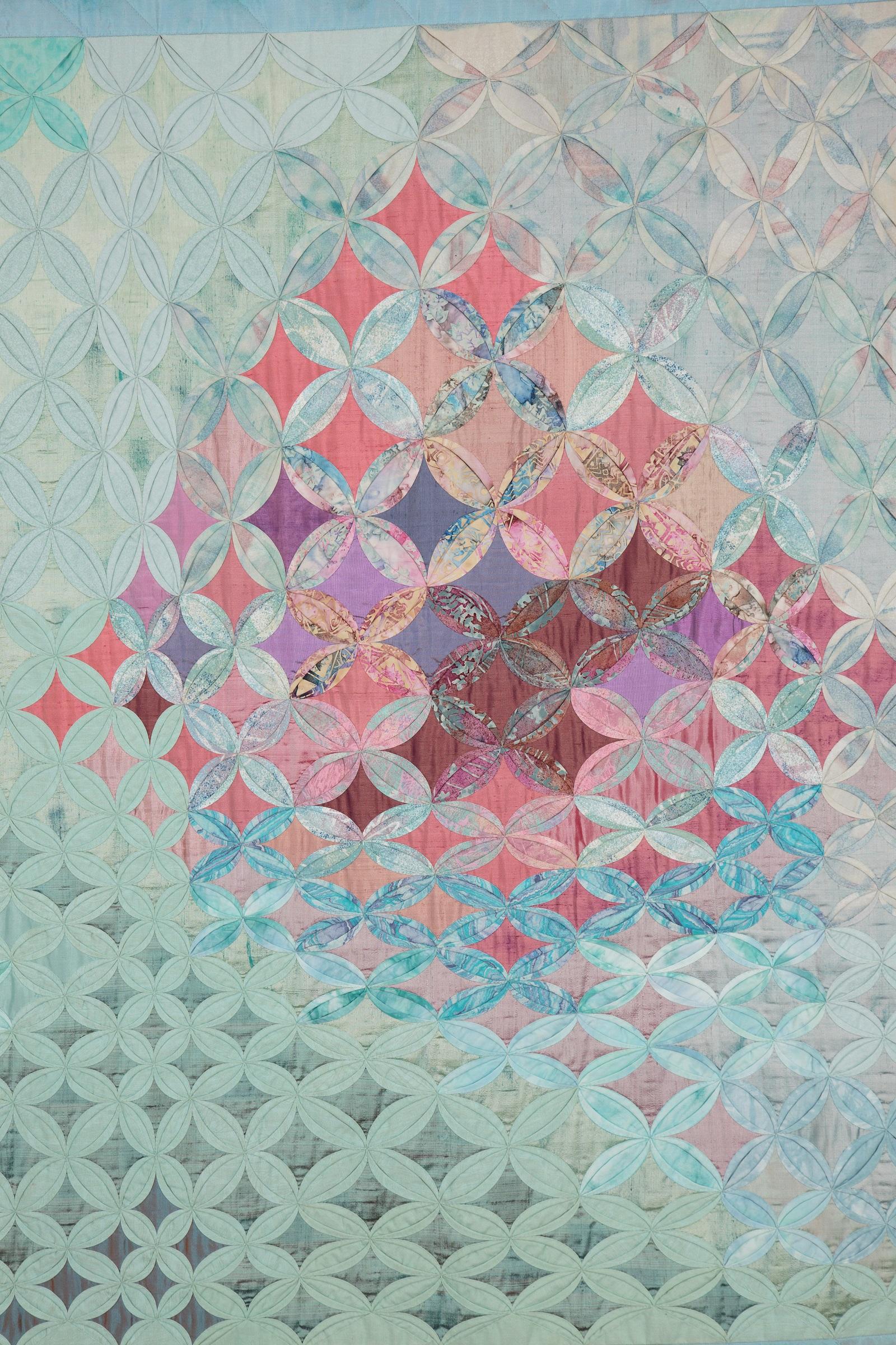 A cathedral windows quilt in purples, blues, turquoises and pinks.