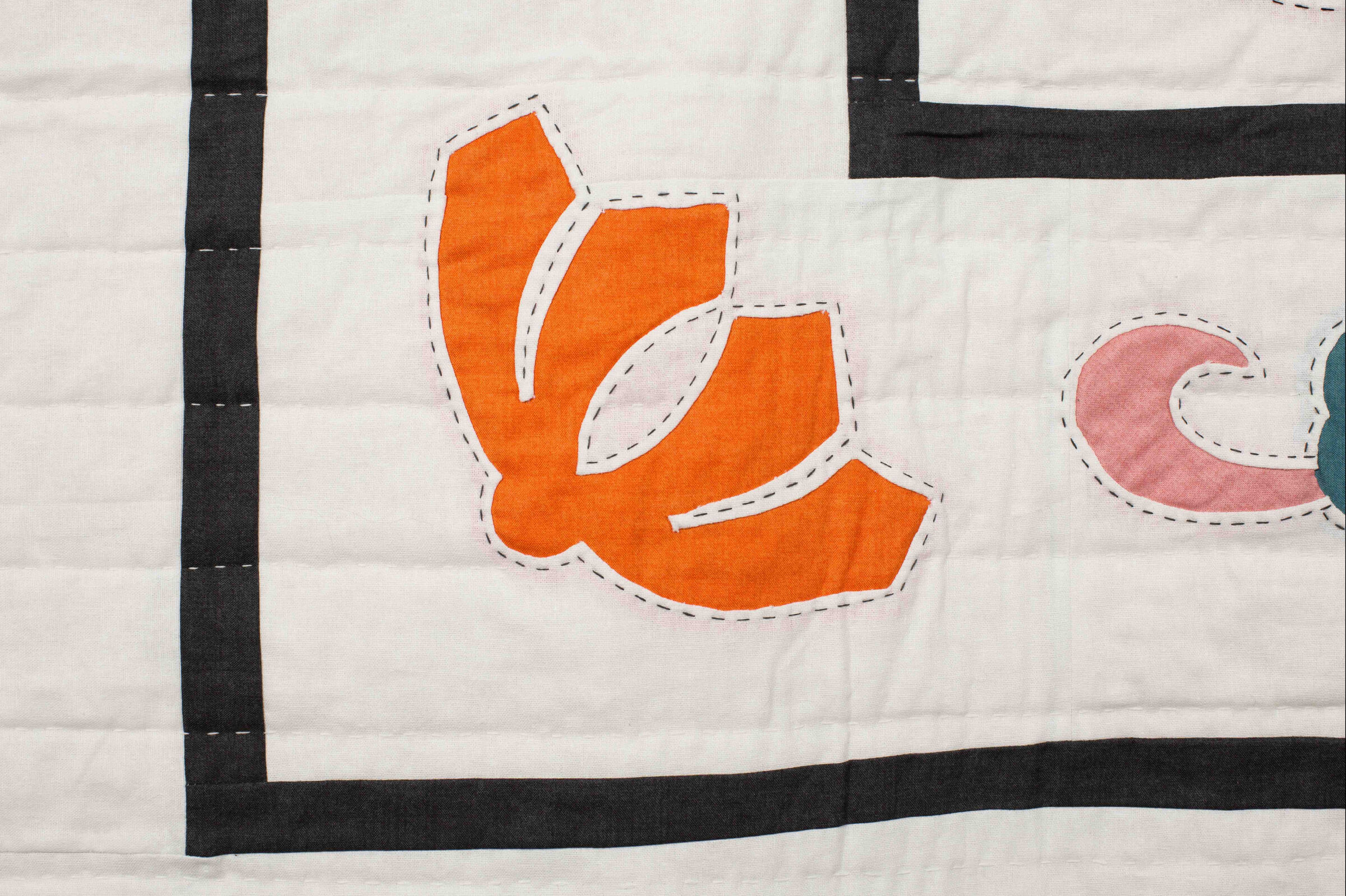 Close-up of appliqué quilt blocks in the Garden Festival pattern showing floral and paisley shapes