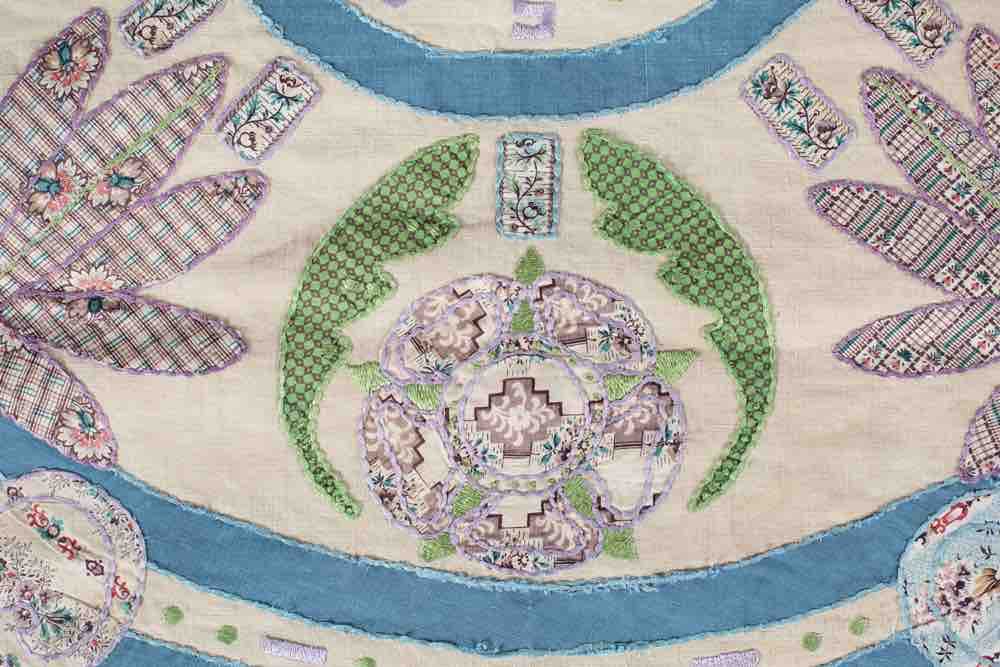 Quilt detail showing hand-finished appliqué and embroidery inspired by a 19th century heritage quilt