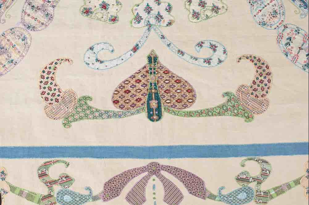 Quilt detail showing hand-finished appliqué and embroidery in a 19th century heritage quilt