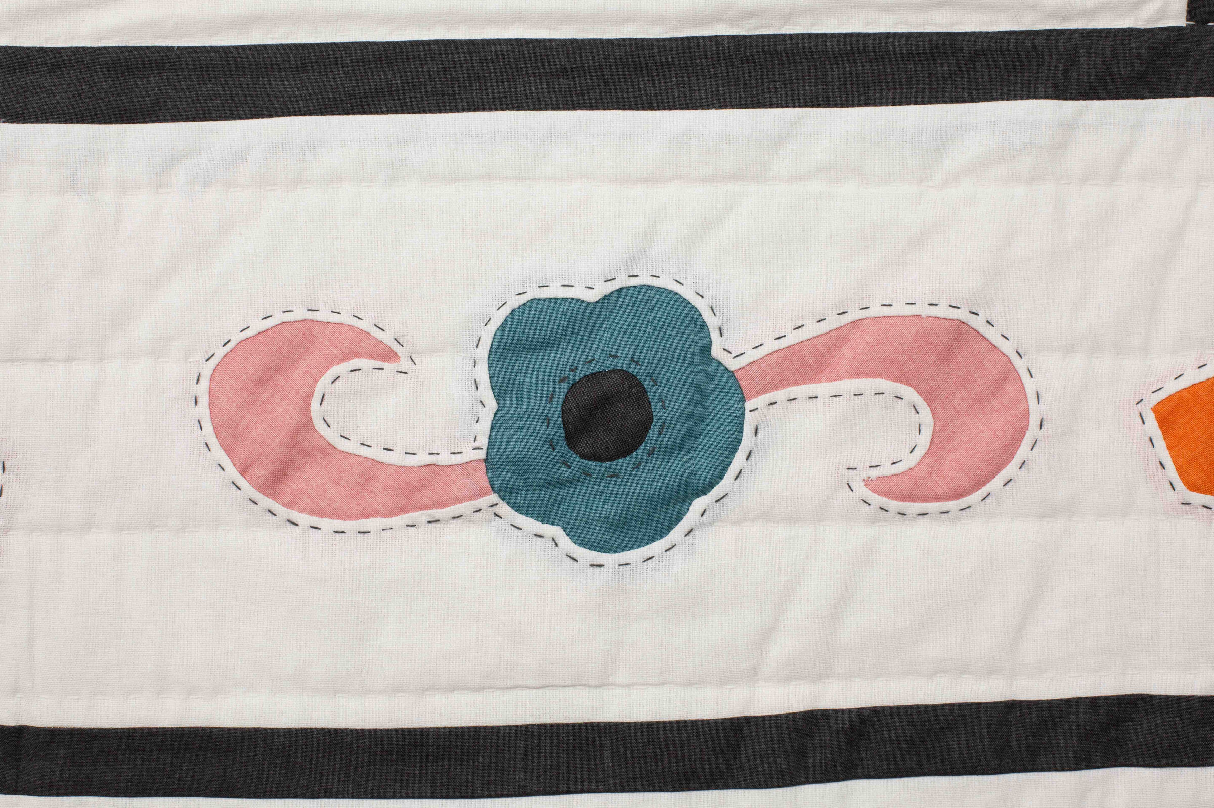 Close-up of appliqué quilt blocks in the Garden Festival pattern showing floral and paisley shapes