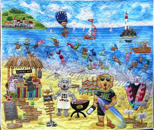 Quilt depicting anthropomorphic dogs barbecuing on a beach.
