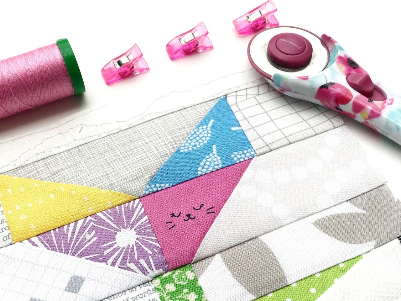 Fabric quilt pieces and equipment on a cutting board