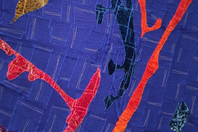 Blue patterned quilt with red and navy detail