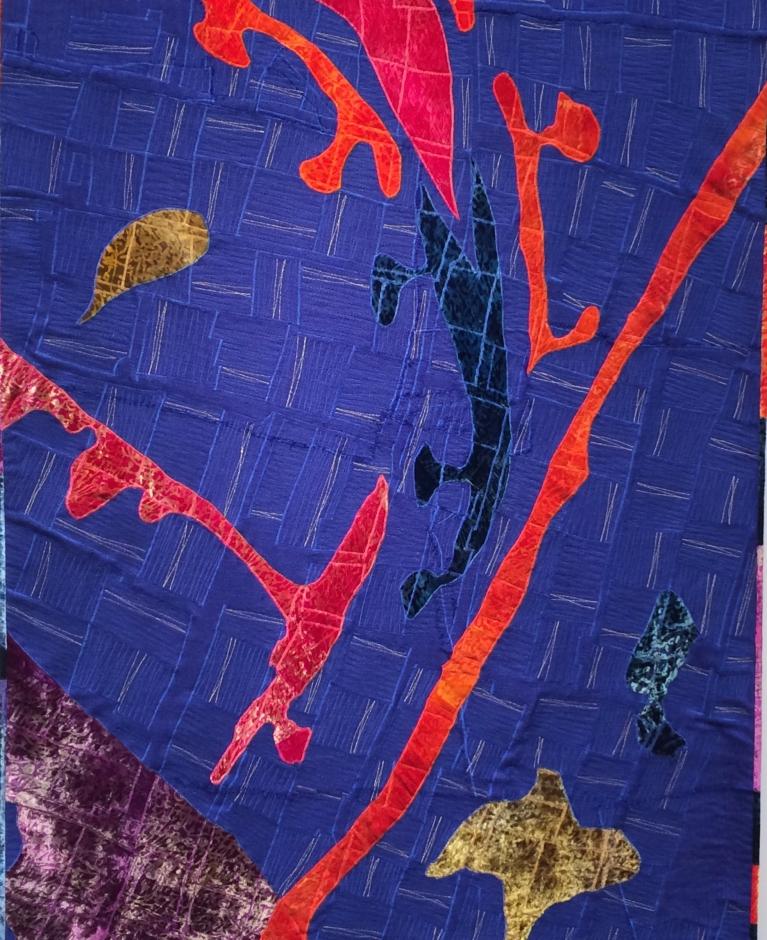 Blue patterned quilt with red, gold and navy detail