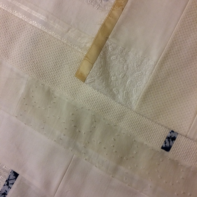 Section of quilt made of different white patterned and textured fabrics