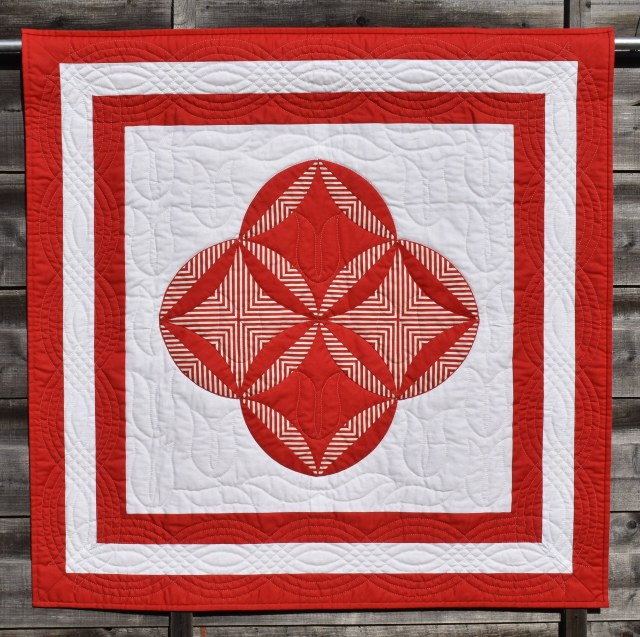 The Burglar by Carolyn Gibbs: white background with a red and white circles and striped central pattern with 2 concentric red borders