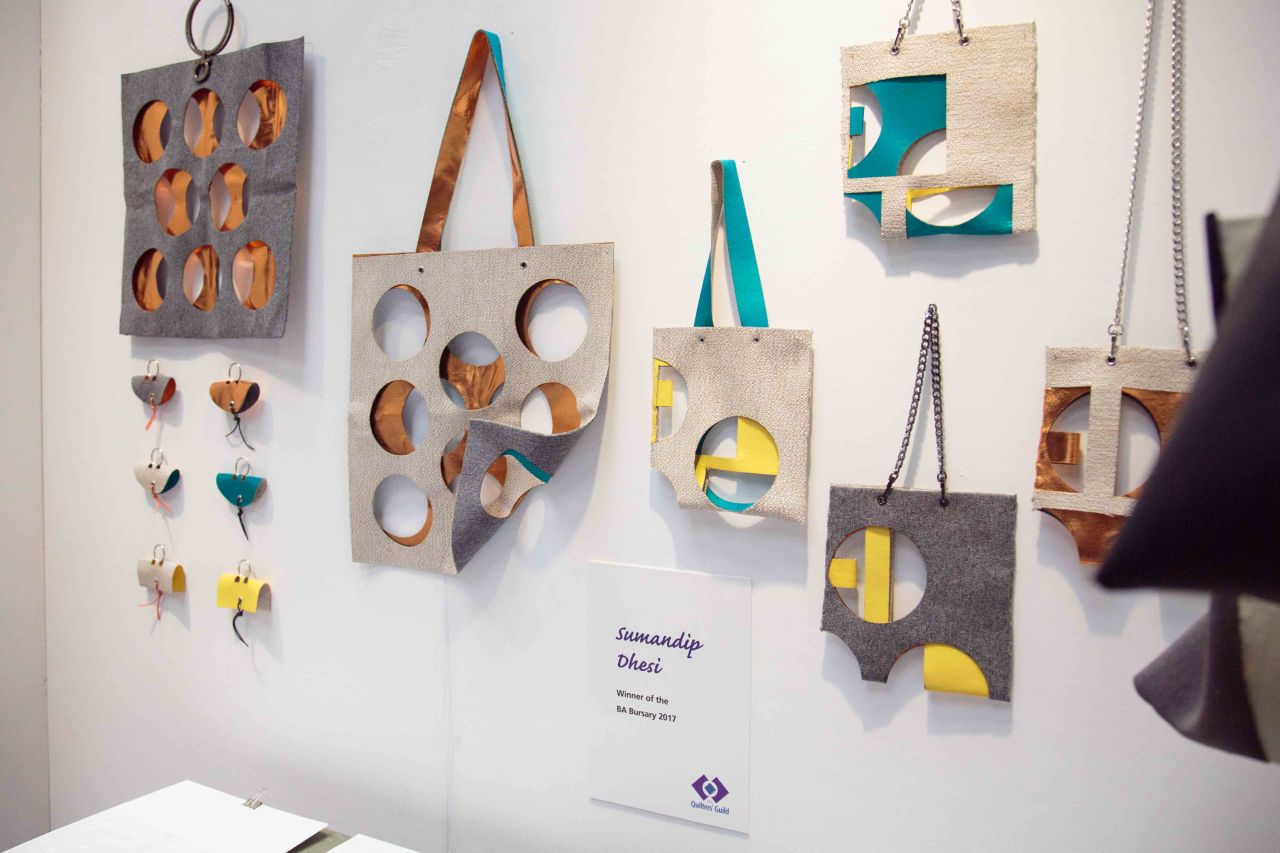 Final exhibition of Sumandip Dhesi, winner of the BA Bursary 2017: Contemporary designed bags on a display wall, made of fabric with cut-out circle designs