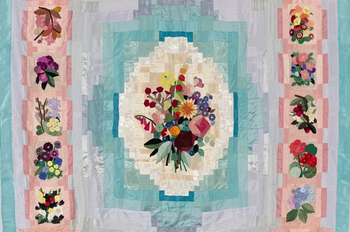 Quilt in pinks and turquoise with a floral design