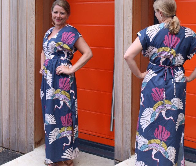 Jenni Smith wearing a ankle length dress made out of fabric in dark blue with a colourful bird pattern