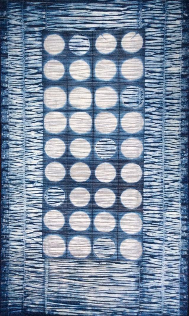 Watery Worlds by Janice Gunner: Quilt made of blue and white horizontal pattern with central rectangle made of white circles 