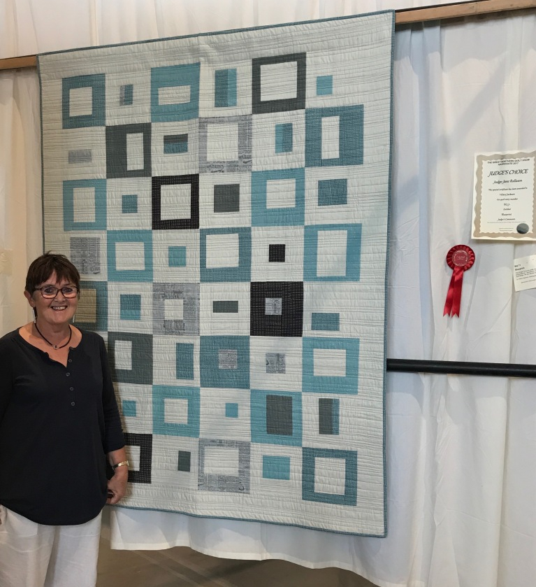 Hilary Jackson stood next to a blue and white quilt on display
