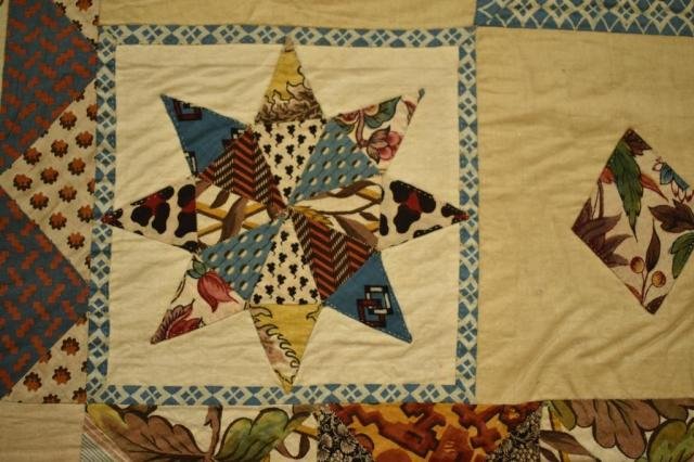 Close up of a patchwork quilt showing a star made of different fabrics
