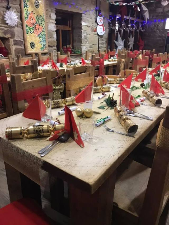 2 long tables in a room set and decorated for a Christmas dinner