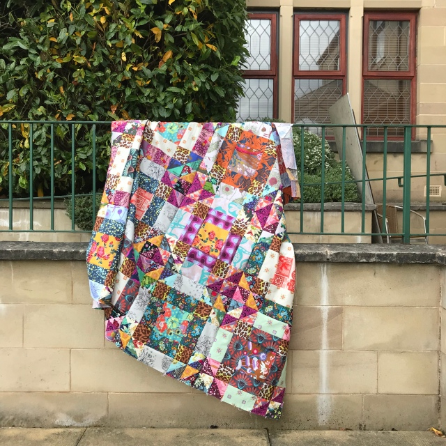 Patchwork quilt draped over a railing
