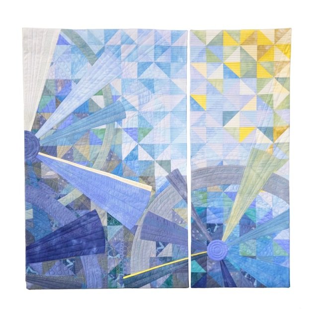 Square quilt made of 2 rectangle pieces using yellow and blue fabric with a wheel and spoke design