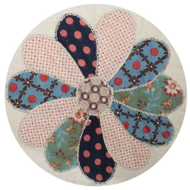 Flower made of 11 petals made of different fabrics each with a cross-stitch border