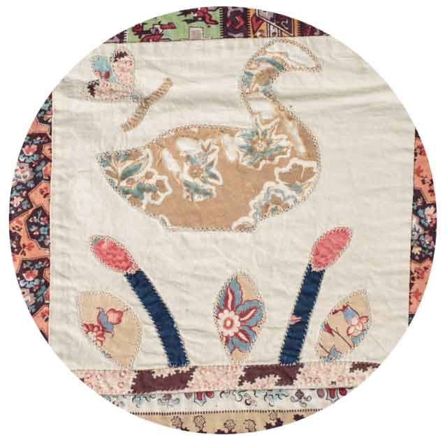 Close up of a swan in a floral fabric on a white background with a butterfly in the corner