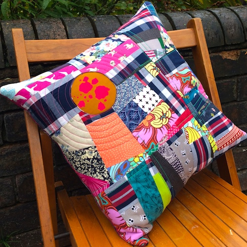 Colourful patchwork cushion on a wooden chair