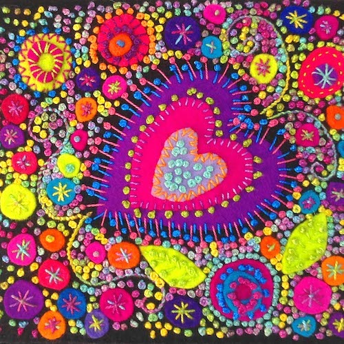 Purple and Pink heart surrounded by yellow and orange felt shapes.