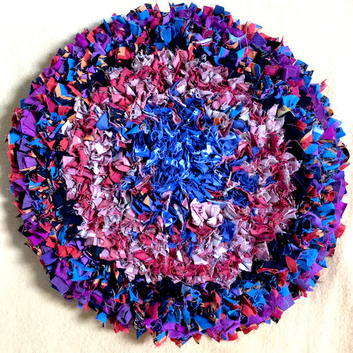 Circle rag rug made of purple blue and pink fabric pieces