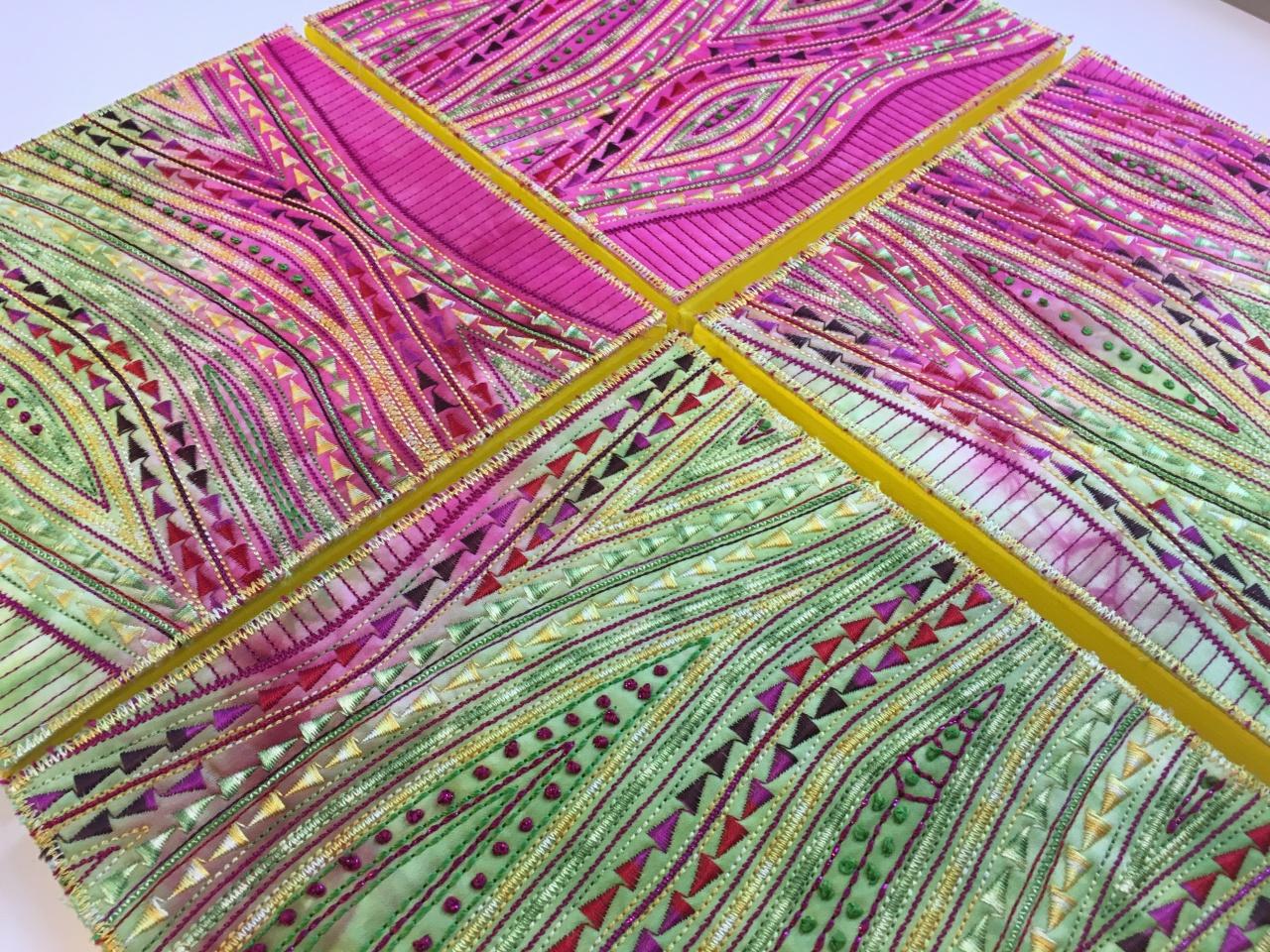 Pink and Green patterned stitching with a yellow cross in the middle