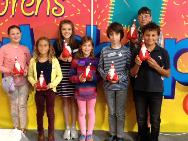 A group of children holding up their finished projects: a quilted Father Christmas