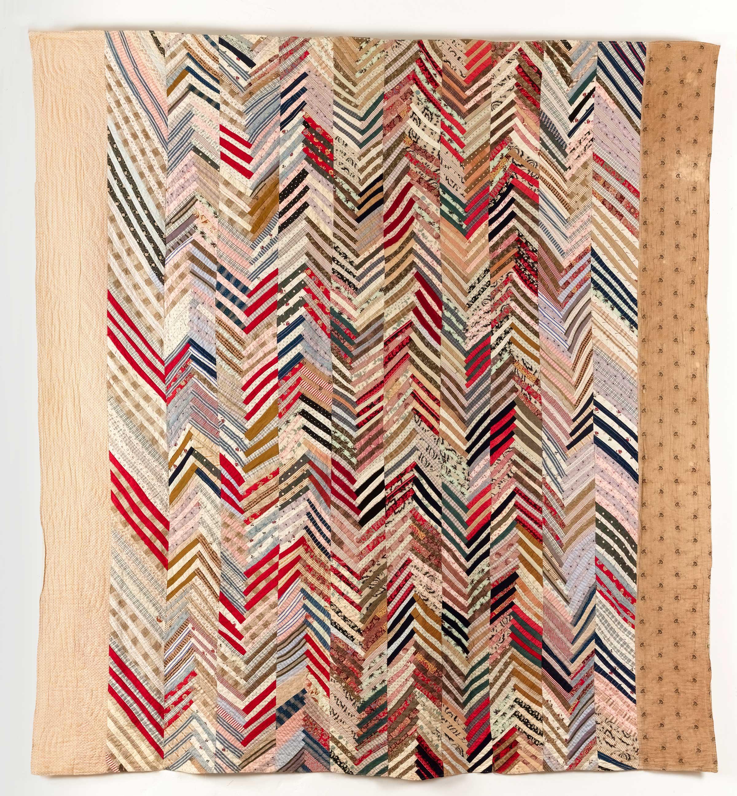 Quilt, where cotton and wool strips have been stitched on lengths which were then joined together