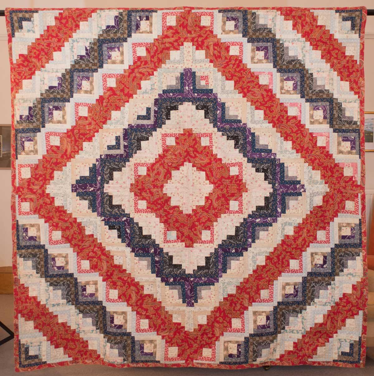 Quilt in blue and red with cascading diamond shapes