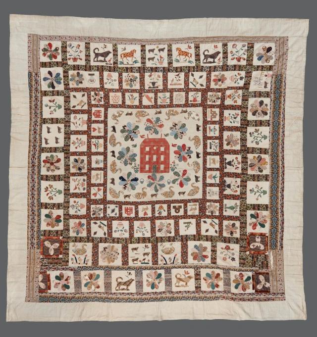 Applique Frame Coverlet with a central motif of a Red Manor House surrounded by flowers and domestic/rural animals. The subsequent frames are divided into squares, with each one containing a different applique motif including flowers, plant pots, animals and houses.