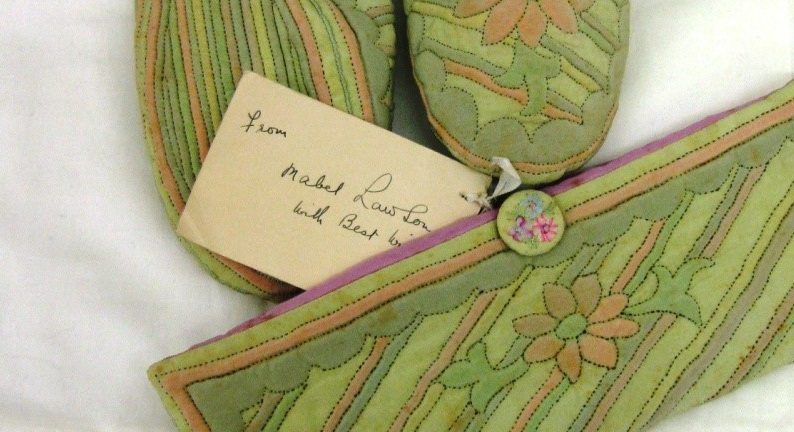 Vintage green quilted slippers and purse with label on which is handwritten 'from Mabel Lawson with Best Wishes'