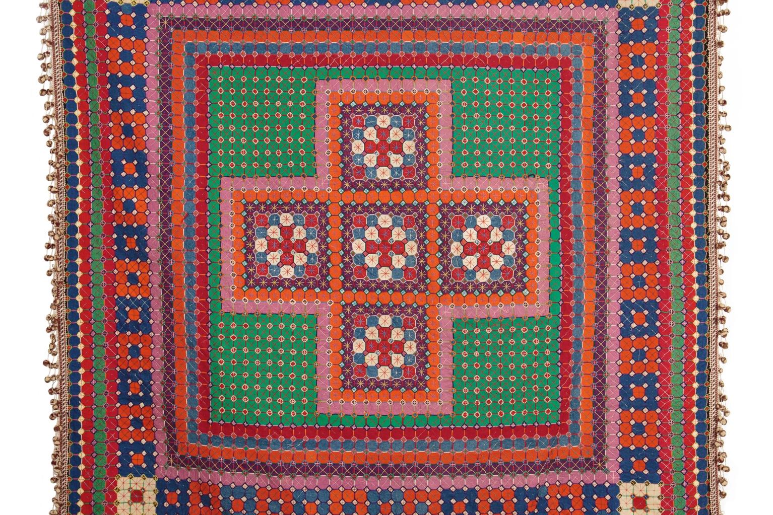 Uncle Tom's Patchwork Coverlet: Orange pink and red cross design with green background and patterned border.