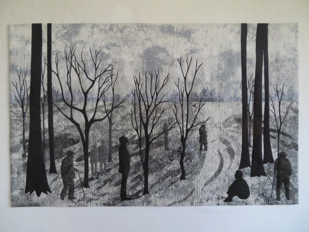 Quilt depicting figures in silhouettes of trees