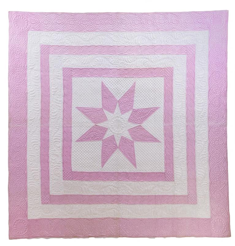 Quilt with a pink and white star in the centre of concentric pink and white squares