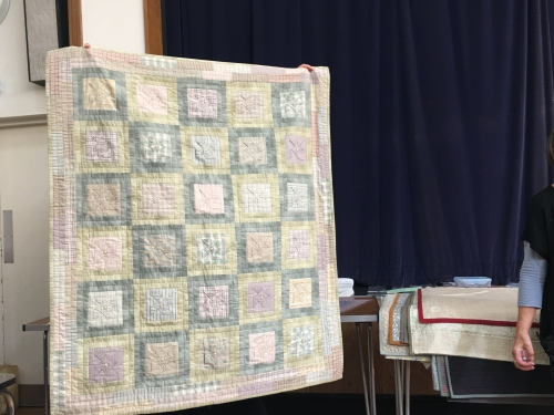 Large quilt made of green, yellow and pink squares