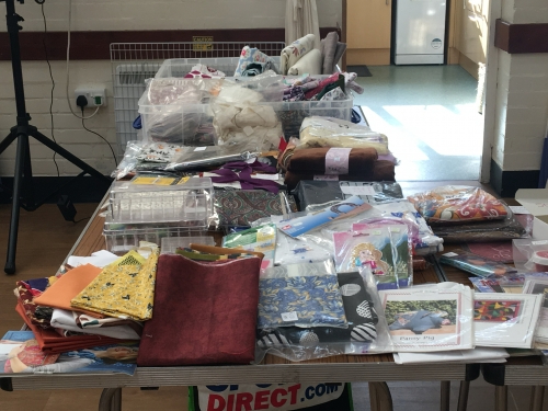 Table covered in piles and bundles of fabric