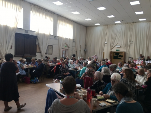 Woman with microphone talking to a hall of people