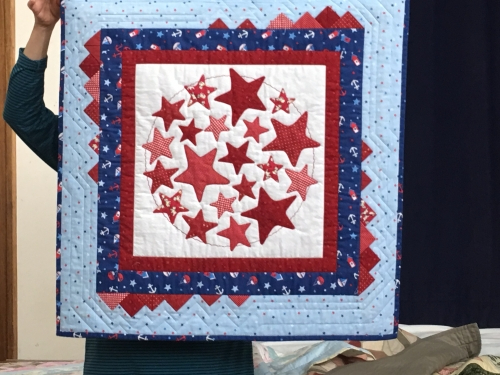 Quilt with Red stars on white background with a dark blue and light blue border