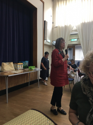 Woman with microphone talking to people in hall