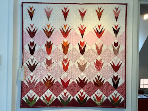 Red and white themed quilt with diamond and geometric tulip pattern