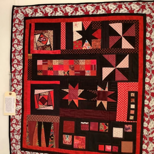 Black and Red themed quilt with a random pattern of squares, triangles, stars and windmills