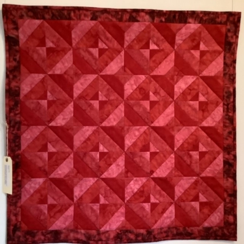 Quilt with repeated diamond made of multiple shades of red