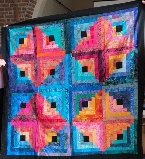 Large quilt with black border and large blue and pink diamond design