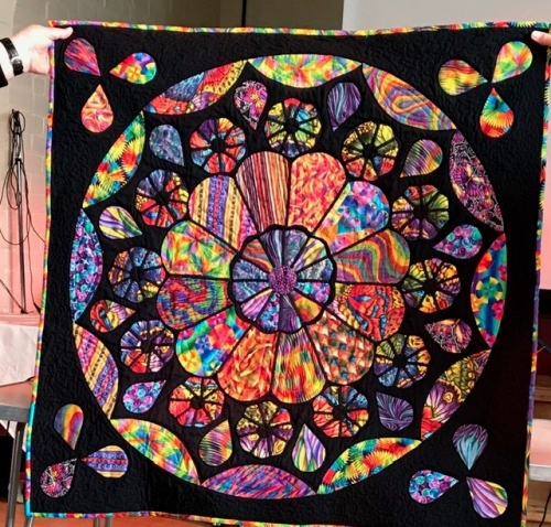 Quilt depicting a stained glass rose window