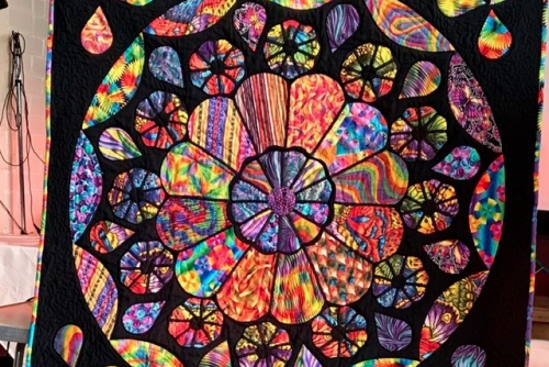 Quilt depicting a stained glass rose window