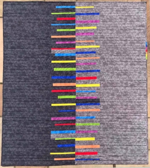 Dark grey and light grey quilt with multi-coloured stripes