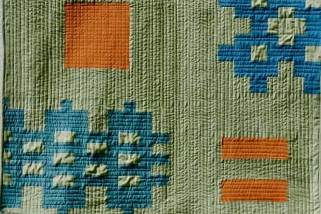 Green quilt with orange and blue pattern
